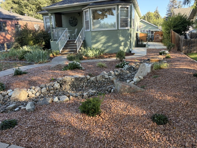 Dry creek, boulders, and new plantings in front of the home